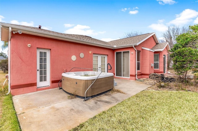 rear view of house featuring french doors, a yard, a hot tub, and a patio area