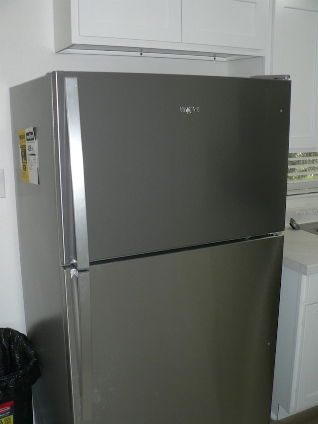 interior details featuring white cabinetry and stainless steel refrigerator