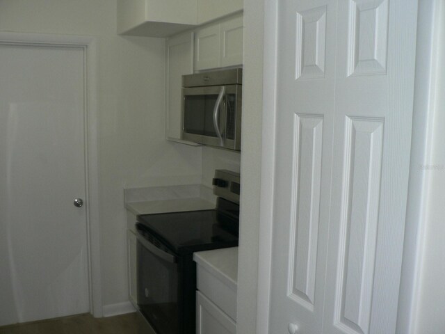 interior space with white cabinetry and stainless steel appliances