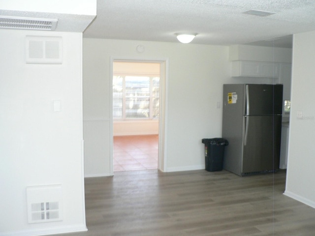 hall featuring wood-type flooring and a textured ceiling