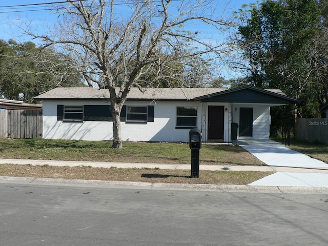 ranch-style home with a carport and a front yard