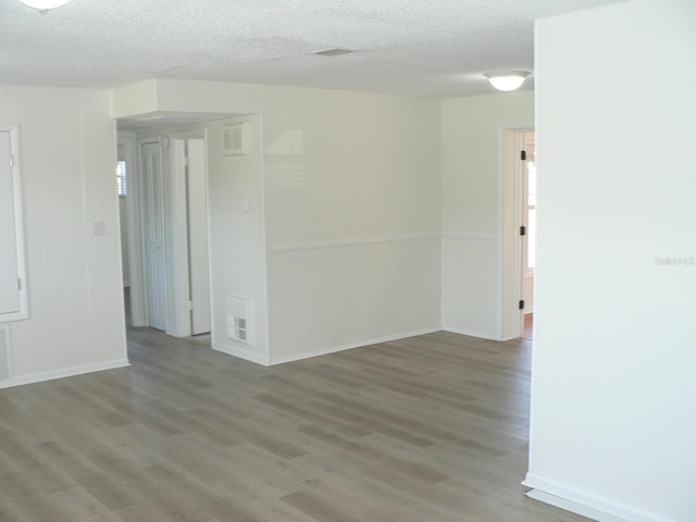 empty room featuring wood-type flooring and a textured ceiling