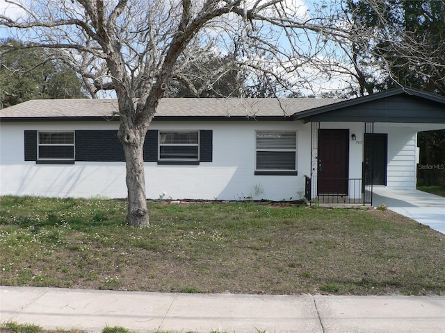 ranch-style house featuring a carport and a front lawn