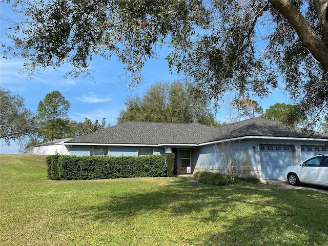 ranch-style house featuring a garage and a front lawn