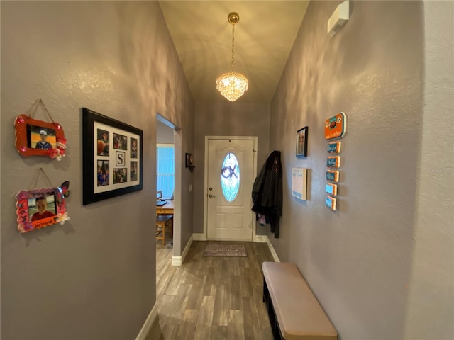 entryway featuring hardwood / wood-style flooring, vaulted ceiling, and a chandelier