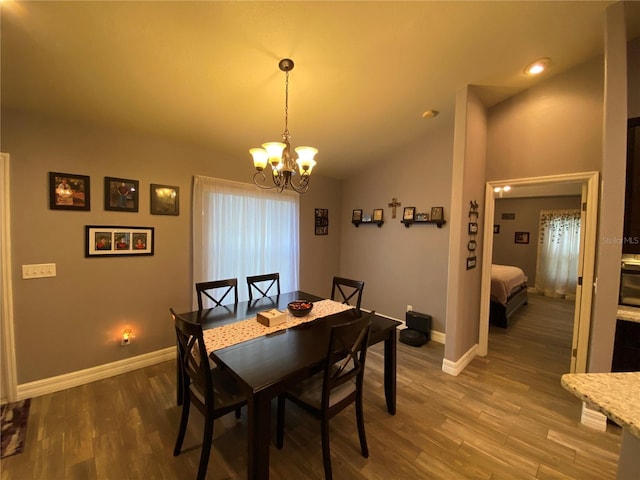 dining area featuring an inviting chandelier, wood-type flooring, and lofted ceiling