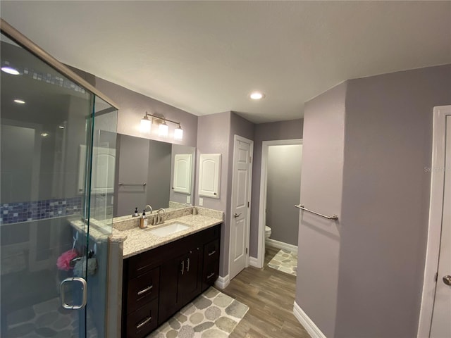 bathroom with vanity, wood-type flooring, toilet, and walk in shower