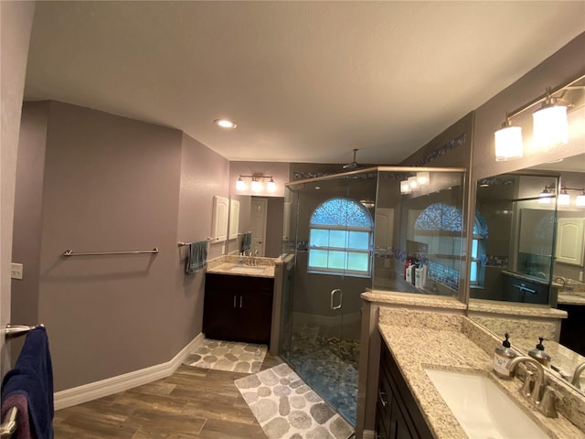 bathroom featuring hardwood / wood-style flooring, vanity, and a shower with door