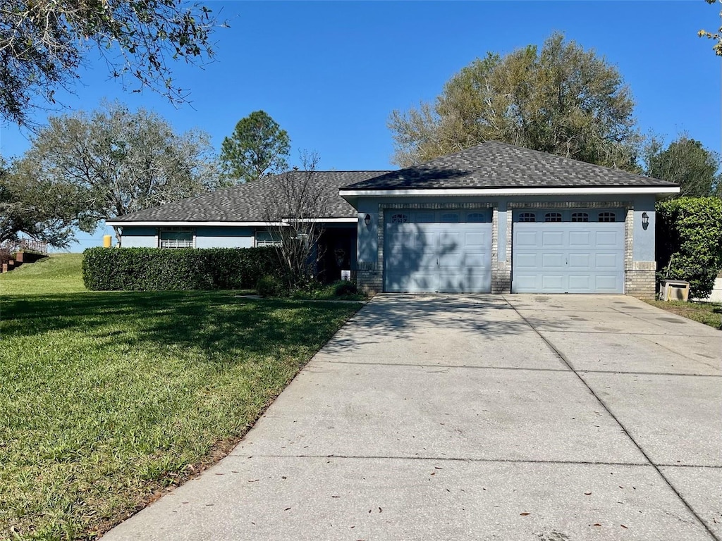 ranch-style home with a garage, a front yard, brick siding, and driveway