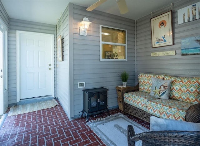 view of exterior entry with a porch and ceiling fan