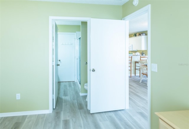 unfurnished bedroom with light wood-type flooring and baseboards