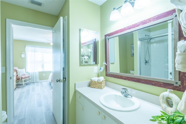 bathroom with visible vents, toilet, a stall shower, ensuite bath, and vanity