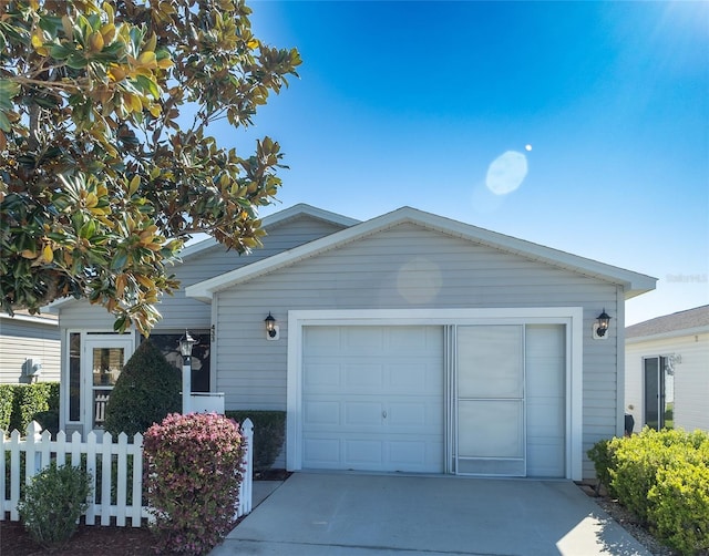 ranch-style home with driveway, a garage, and fence