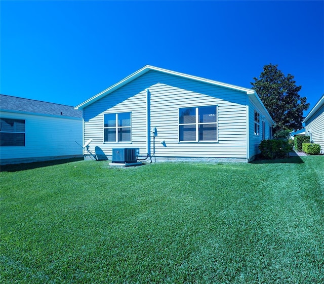 view of side of home featuring cooling unit and a yard