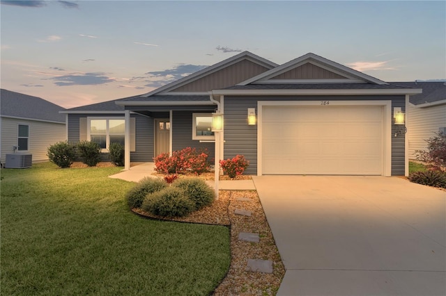 view of front of property featuring central AC unit, a garage, and a lawn