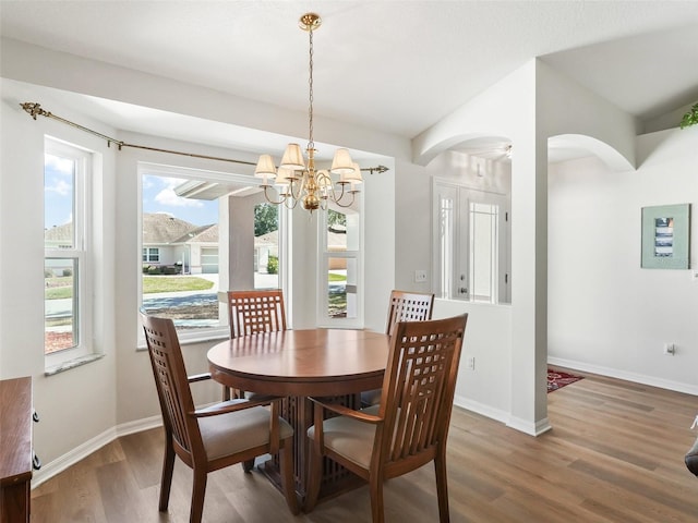 dining area with an inviting chandelier and dark hardwood / wood-style floors