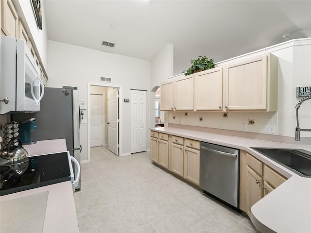 kitchen with range with electric cooktop, light brown cabinetry, dishwasher, and sink