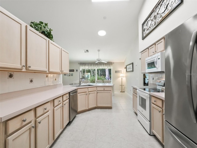 kitchen with sink, appliances with stainless steel finishes, decorative backsplash, kitchen peninsula, and light brown cabinets