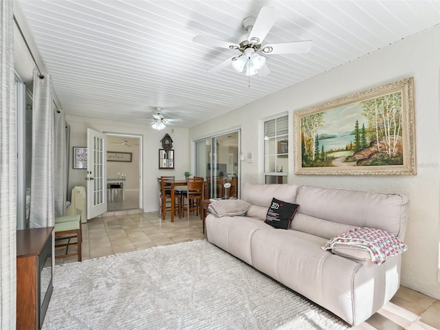 living room featuring light tile patterned floors, ceiling fan, and french doors