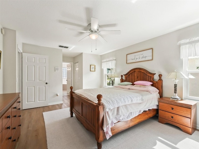 bedroom featuring multiple windows, ceiling fan, and light hardwood / wood-style floors