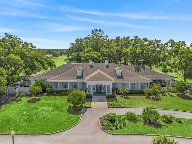 view of front of property with french doors, a front yard, and a chimney