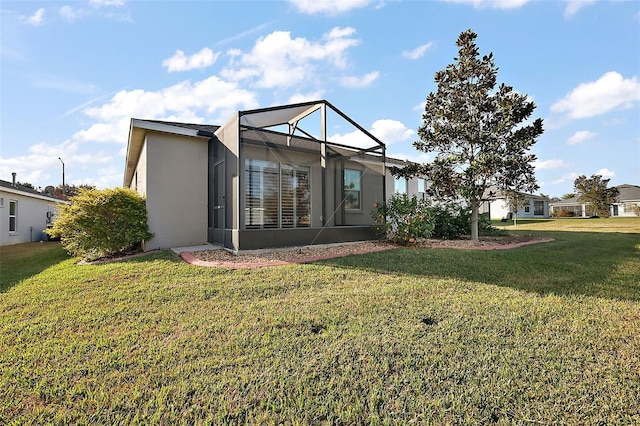 rear view of house featuring a yard and a lanai