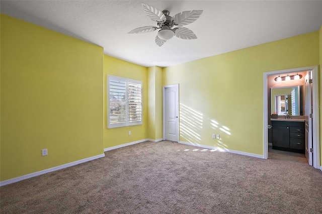 unfurnished bedroom with ceiling fan, ensuite bathroom, and carpet floors