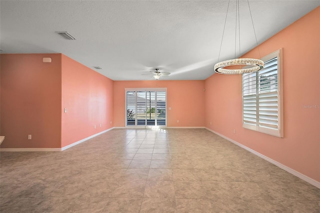 spare room with a textured ceiling, ceiling fan, and light tile patterned flooring