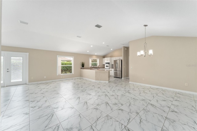 unfurnished living room featuring vaulted ceiling and a chandelier