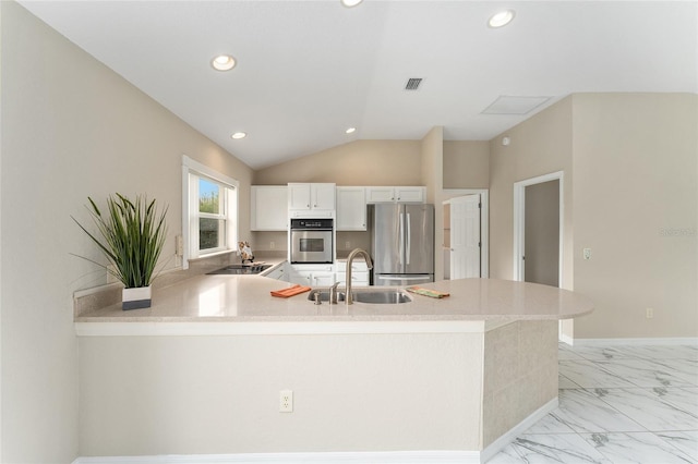 kitchen featuring sink, white cabinetry, vaulted ceiling, appliances with stainless steel finishes, and kitchen peninsula