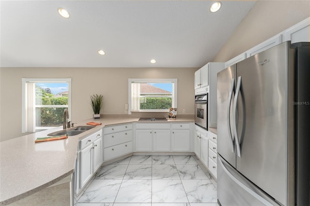 kitchen with stainless steel appliances, white cabinetry, plenty of natural light, and sink