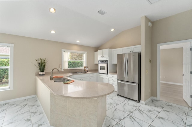 kitchen with sink, kitchen peninsula, white cabinets, and appliances with stainless steel finishes