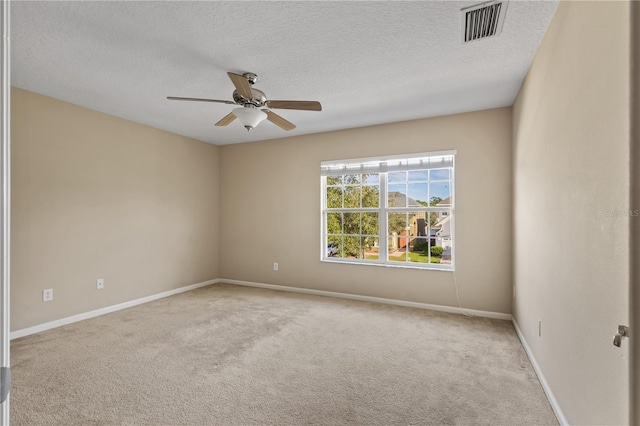 carpeted spare room featuring ceiling fan and a textured ceiling