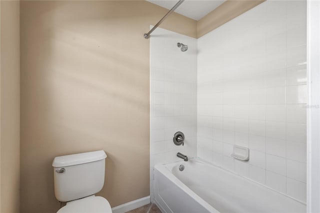 bathroom with tiled shower / bath combo and toilet