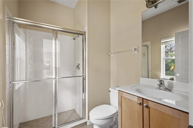 bathroom with a shower with door, vanity, and toilet