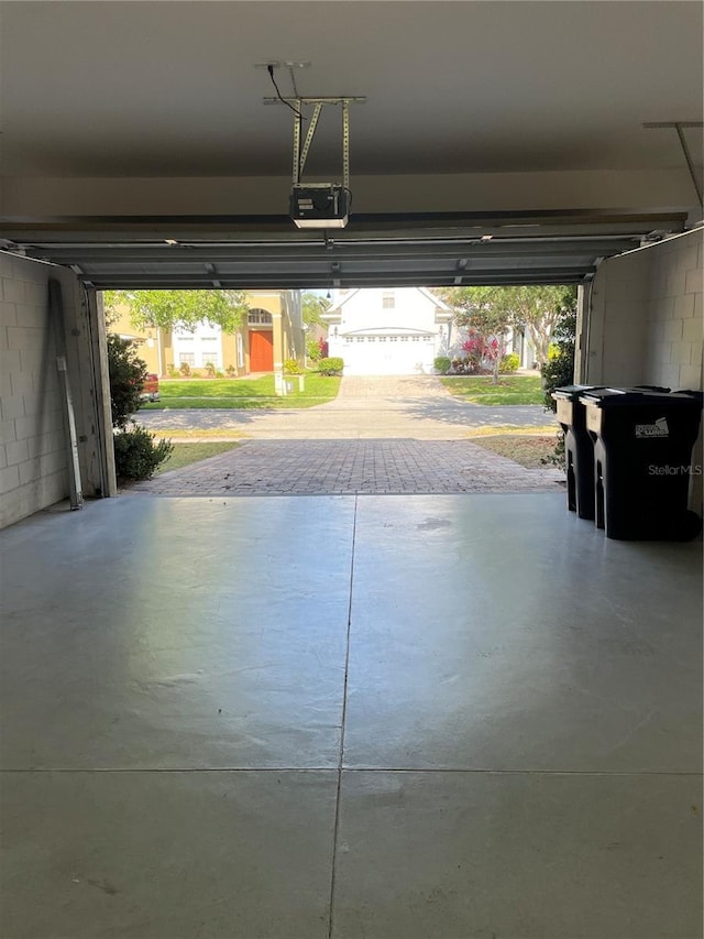 garage with a garage door opener and concrete block wall