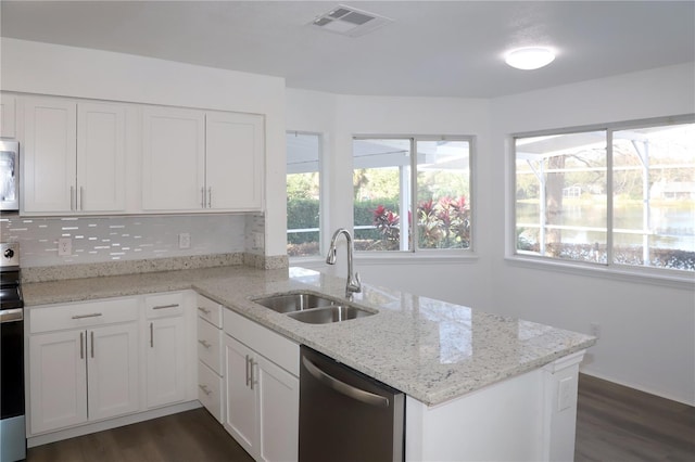 kitchen with sink, dark wood-type flooring, stainless steel appliances, light stone countertops, and white cabinets