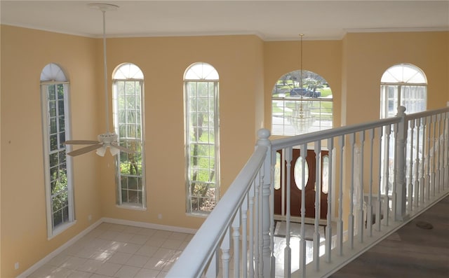 hall featuring crown molding, light tile patterned flooring, and a chandelier