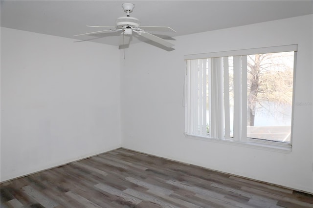 empty room with ceiling fan and dark hardwood / wood-style flooring