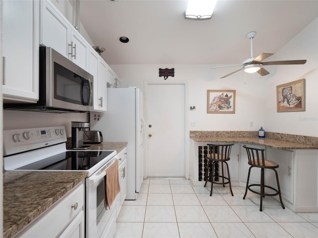 kitchen with electric stove, ceiling fan, stone counters, and white cabinets