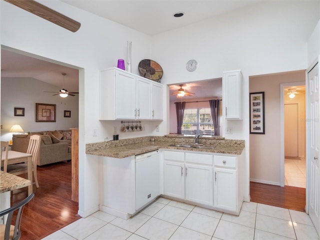 kitchen featuring sink, white cabinetry, stone countertops, vaulted ceiling, and dishwasher