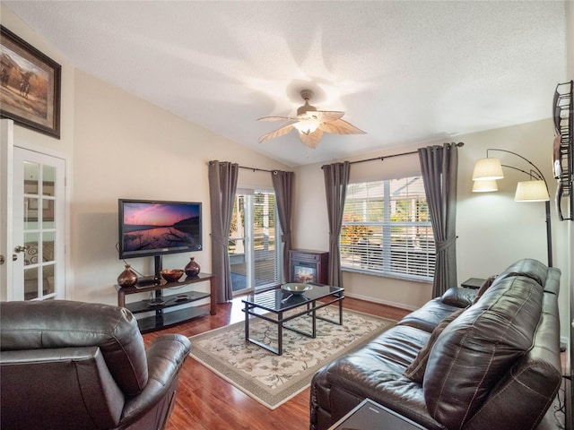 living room with lofted ceiling, a textured ceiling, wood-type flooring, and ceiling fan