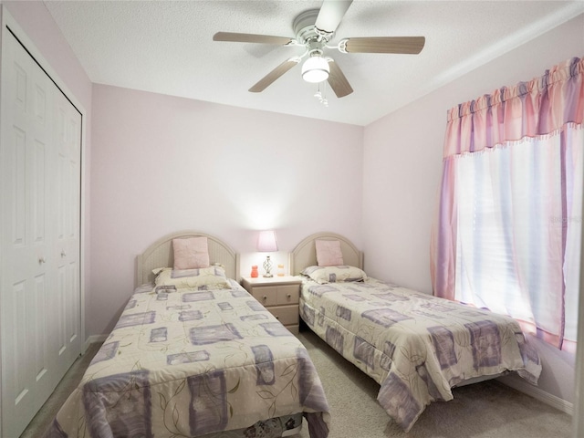 bedroom with carpet flooring, a textured ceiling, ceiling fan, and a closet