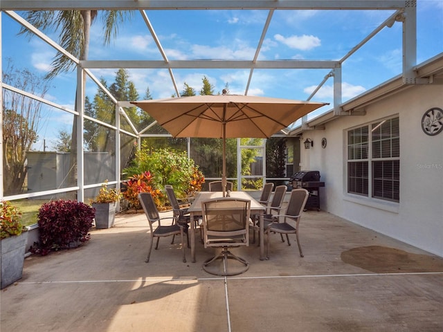 view of patio with area for grilling and glass enclosure