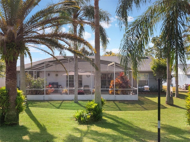 back of house featuring a lanai and a lawn