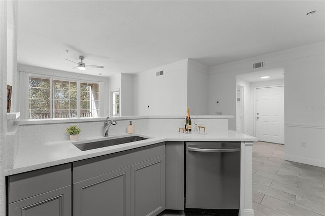 kitchen featuring sink, gray cabinetry, dishwasher, kitchen peninsula, and ceiling fan