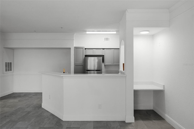 kitchen featuring stainless steel fridge and kitchen peninsula