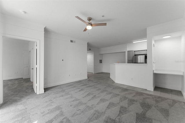 unfurnished living room featuring ceiling fan and light colored carpet