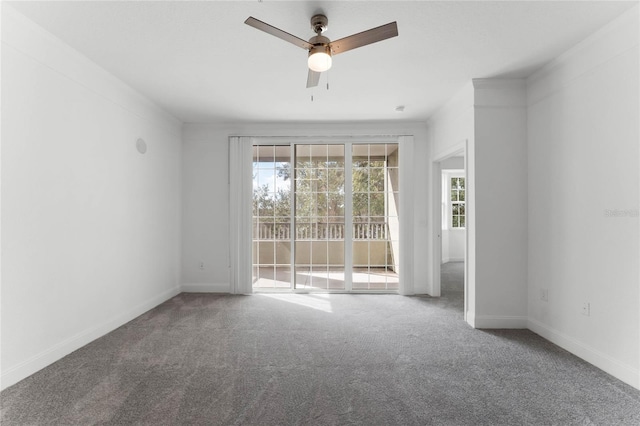 carpeted spare room featuring ceiling fan