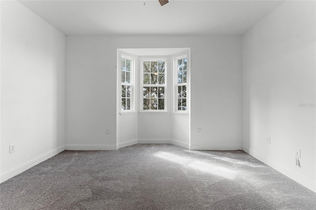 spare room with ceiling fan and carpet